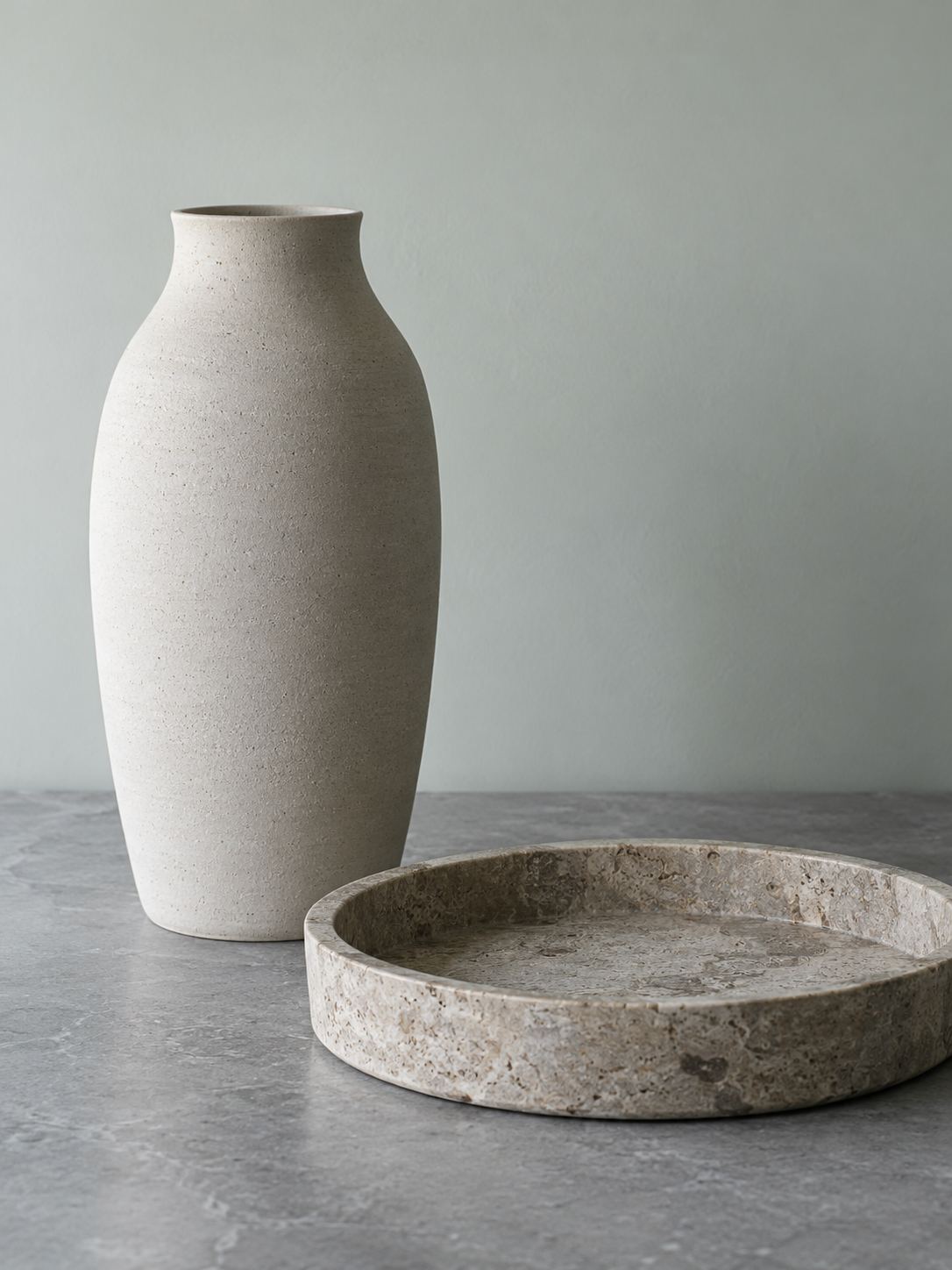 A matte ceramic vase and a stone tray